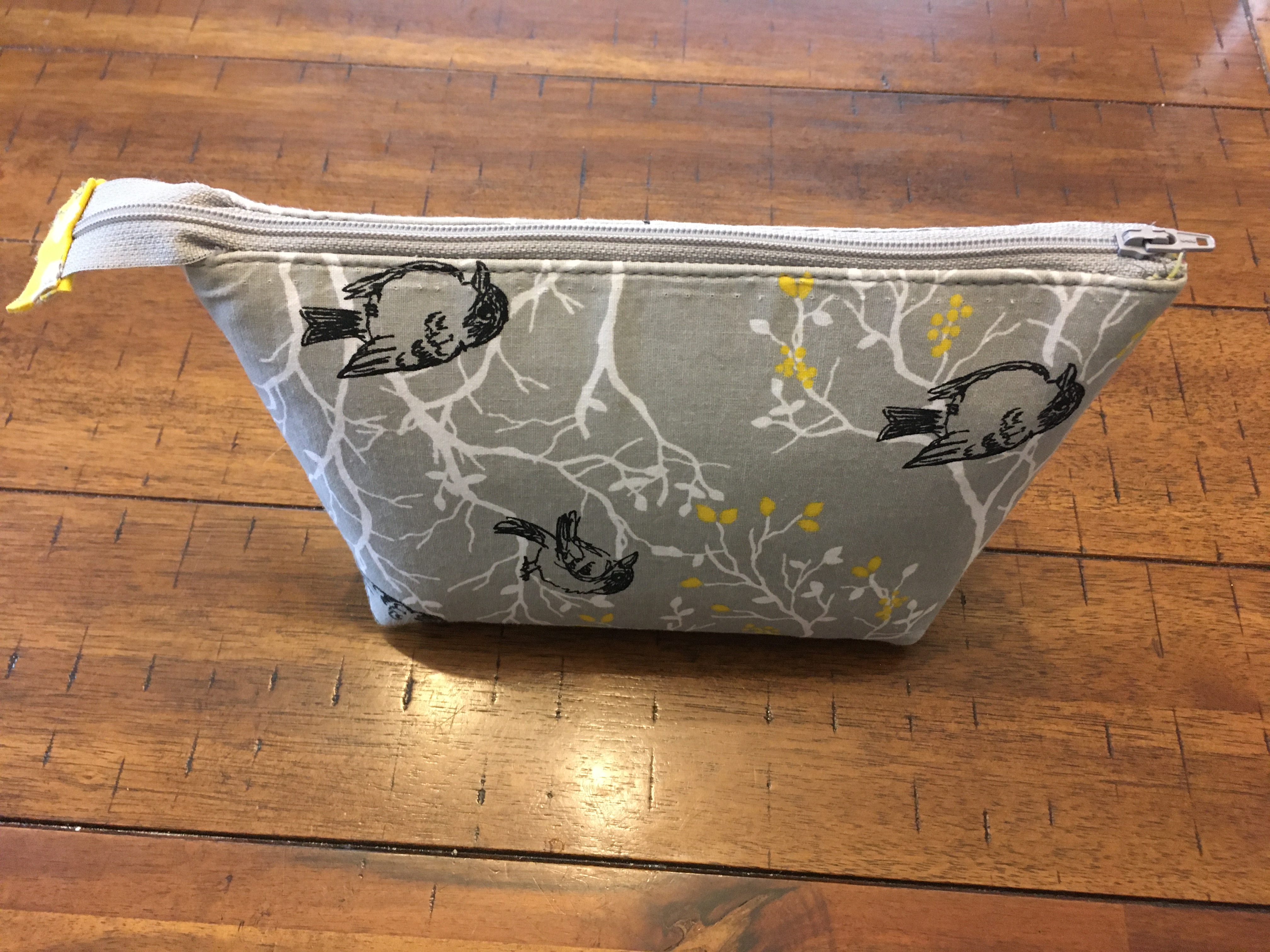 Small gray fabric pouch with zipper on top
