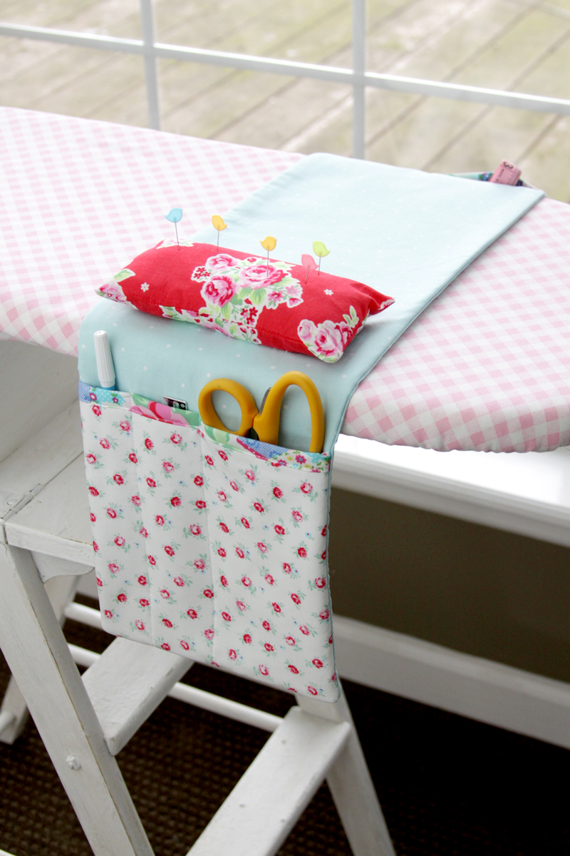 Image of ironing board with fabric organizer holding scissors and sewing notions