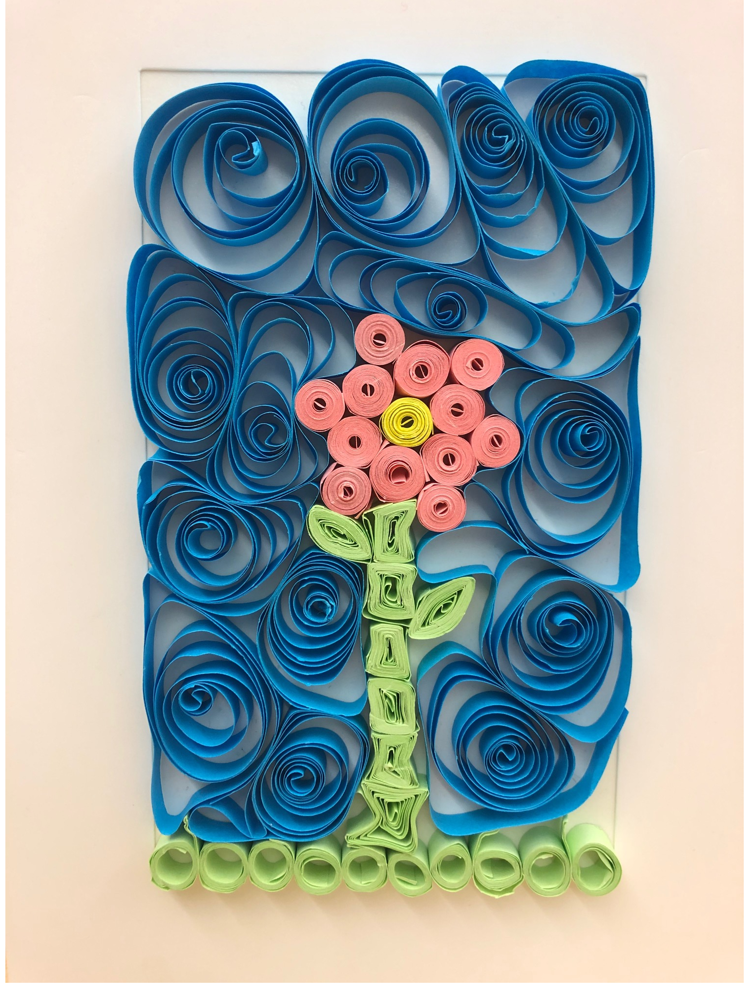 pink flower with blue sky made via paper quilling