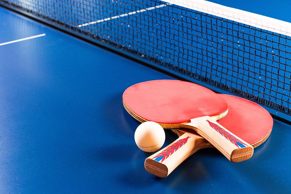 photo of red table tennis rackets on a blue table